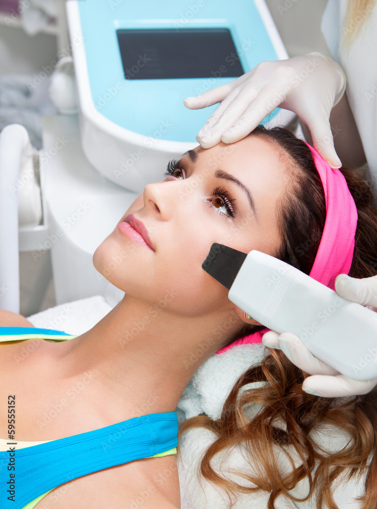 Naklejka premium Woman getting laser face treatment in medical spa center