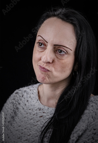 Portrait of a woman thinking, black background