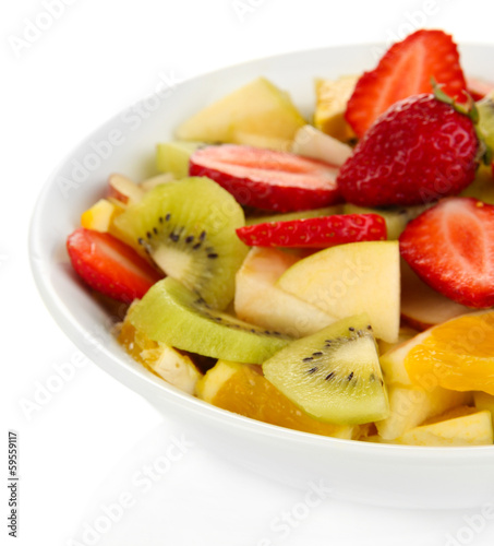 Useful fruit salad of fresh fruits and berries in bowl isolated