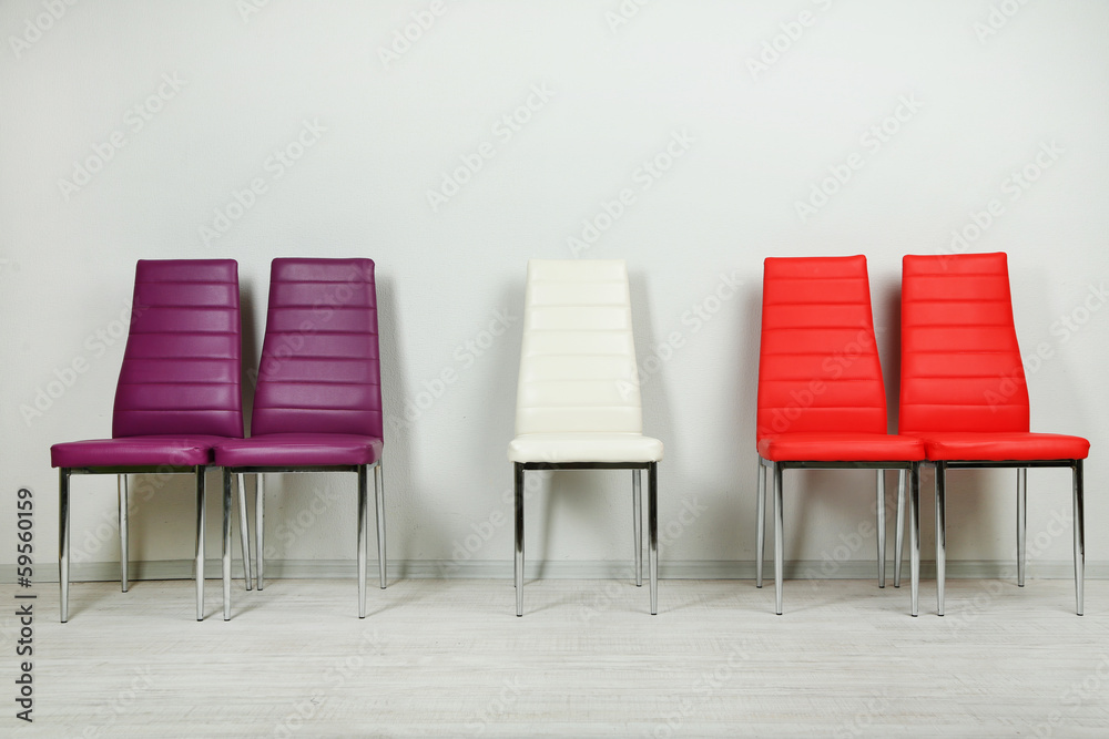 Modern color chairs on wall background Modern color chairs on wall background