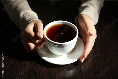 Hands holding mug of hot drink  close-up