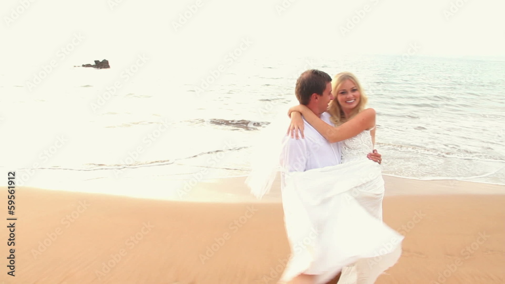 Newly married couple on tropical beach after sunset wedding, Rom Newly married couple on tropical beach after sunset wedding, Rom