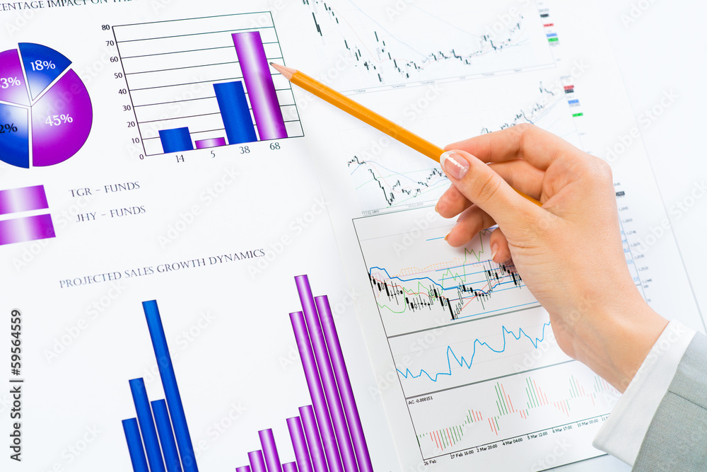 female hand pointing pencil on financial charts female hand pointing pencil on financial charts