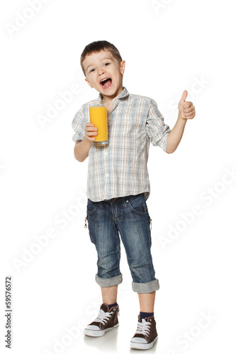 Little boy with a glass of juice lifts finger upwards.