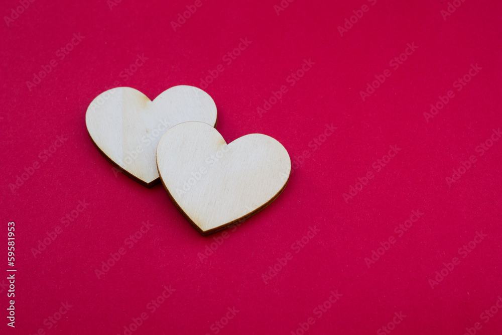 Valentine's day card with two wooden hearts symbol on red surfac