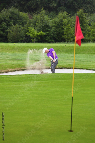 Golfer playing out of a bunker