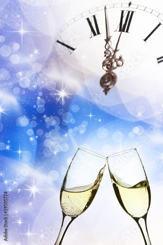 Glasses with champagne against old clock