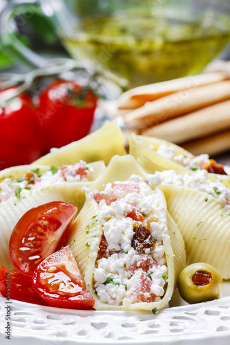 Italian cuisine: stuffed pasta shells and stack of breadsticks.