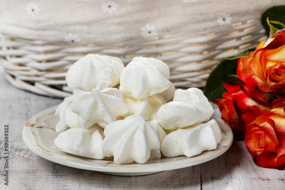 Stack of meringues. Red roses in the background Stack of meringues. Red roses in the background