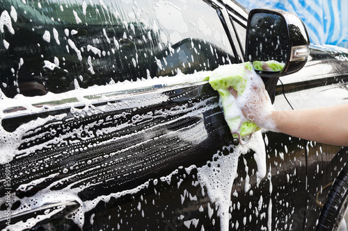 Foto hands hold sponge  for washing car