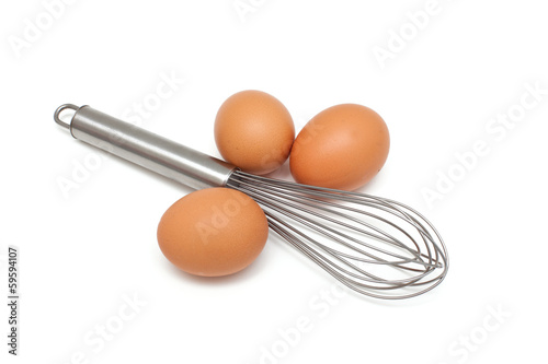 fresh eggs and metallic whisk