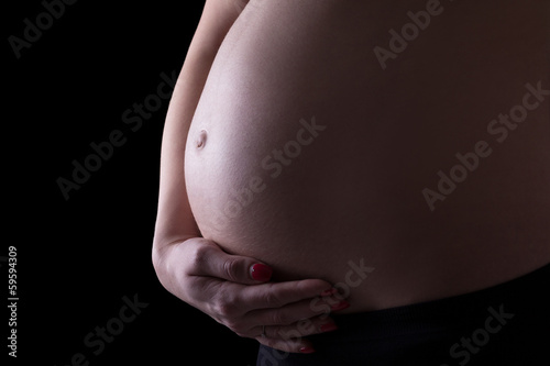 pregnant woman's belly isolated on black