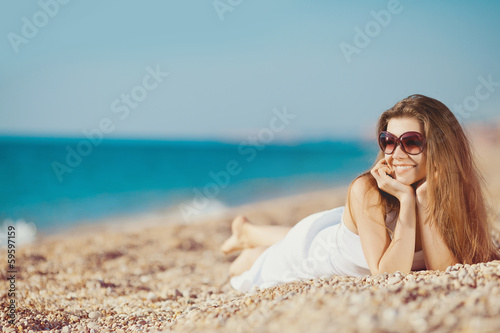 portrait of a beautiful young woman on the beach in the sand