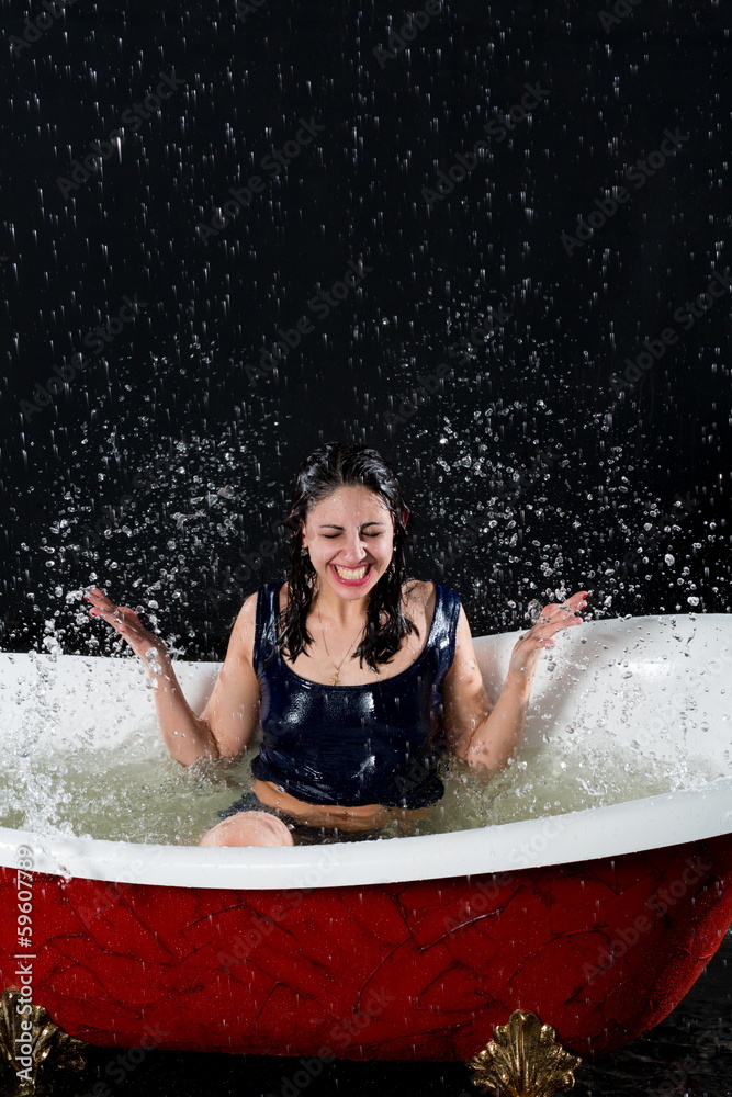 Smiling girl with closed eyes splashes water in bathtub Smiling girl with closed eyes splashes water in bathtub