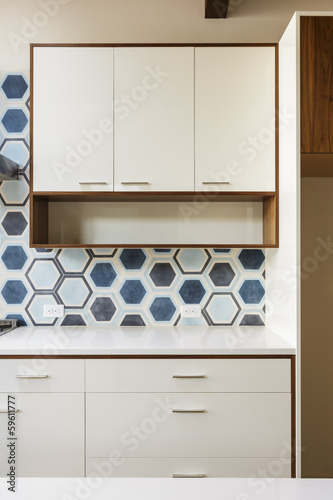White kitchen cabinet in modern home with blue tile