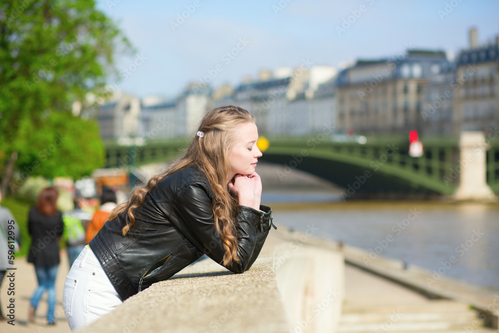 Thoughtful Parisian girl at the Seine embankment
