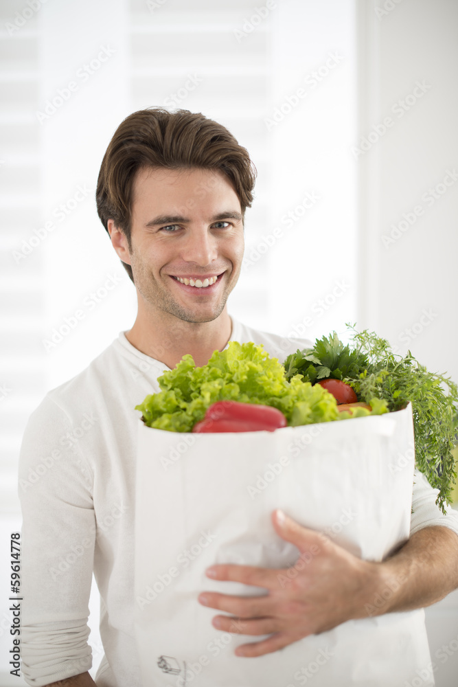 man with a vegetables's bag in his arms man with a vegetables's bag in his arms