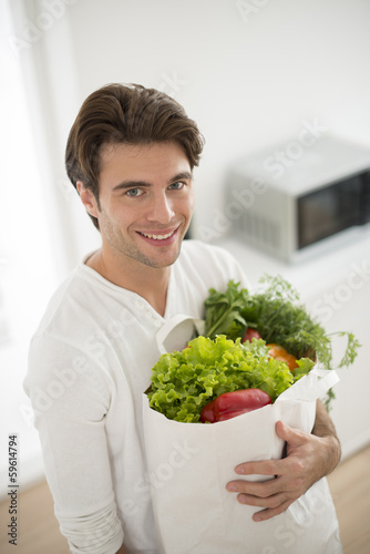 man with a vegetables's bag in his arms