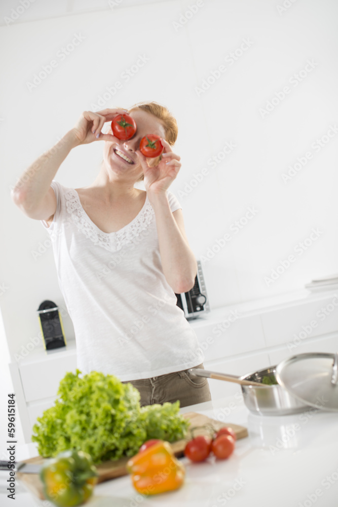 woman in the kitchen makes a joke with tomatoes on her eyes woman in the kitchen makes a joke with tomatoes on her eyes
