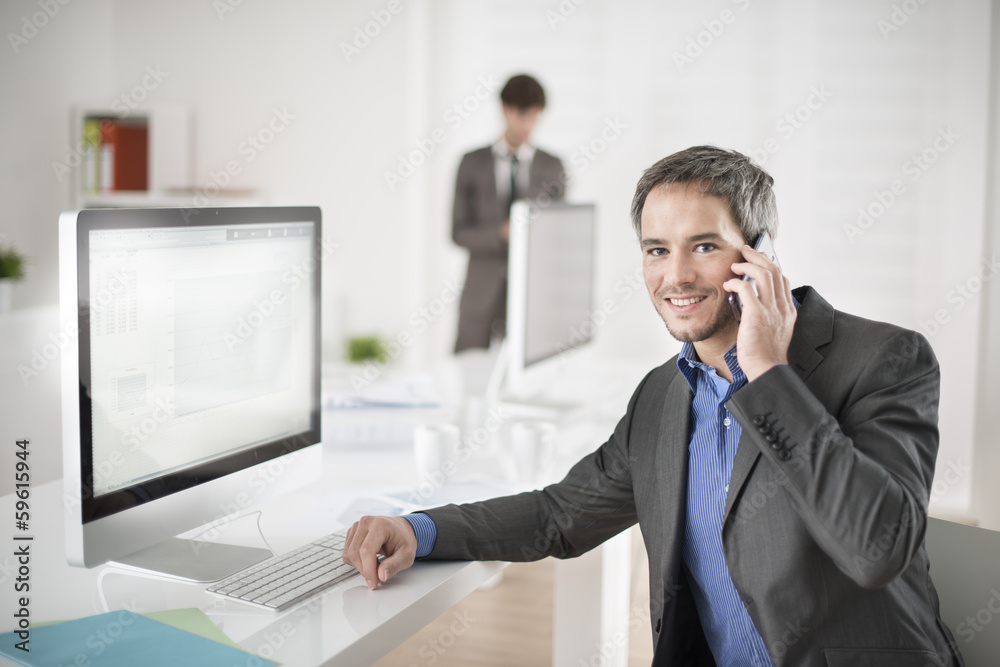 businessman at phone in office looking at camera businessman at phone in office looking at camera