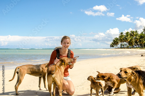 Junge Frau mit Strandhunden in der Karibik photo