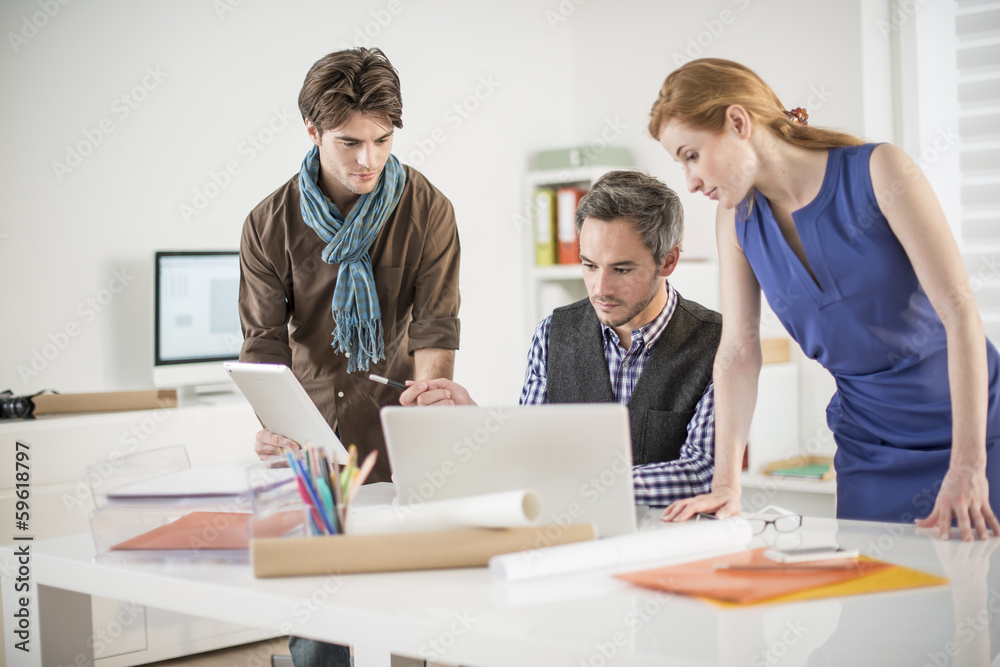 Obraz premium team discusses about a work project around a computer