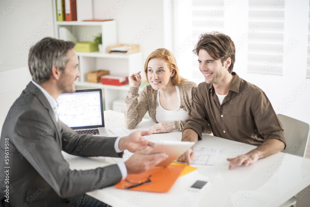 Obraz premium real-estate agent receives a young couple interested to invest i
