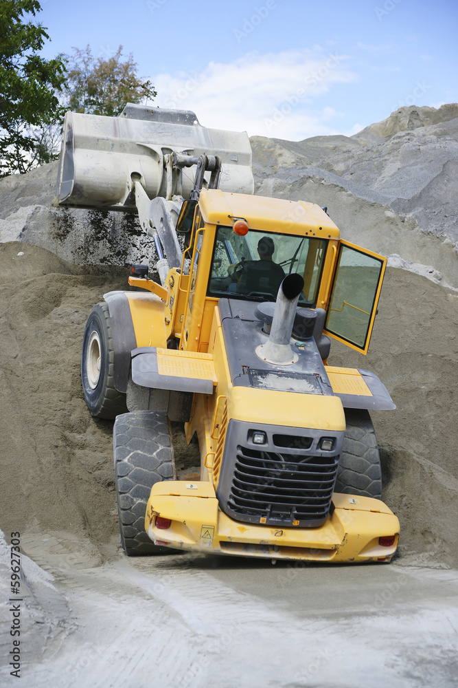 Wheel loader Excavator unloading sand during earth moving works Wheel loader Excavator unloading sand during earth moving works