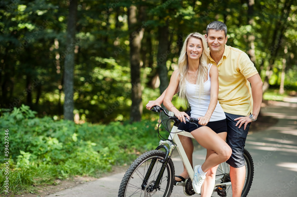 Attractive happy couple on a bicycles in a countryside