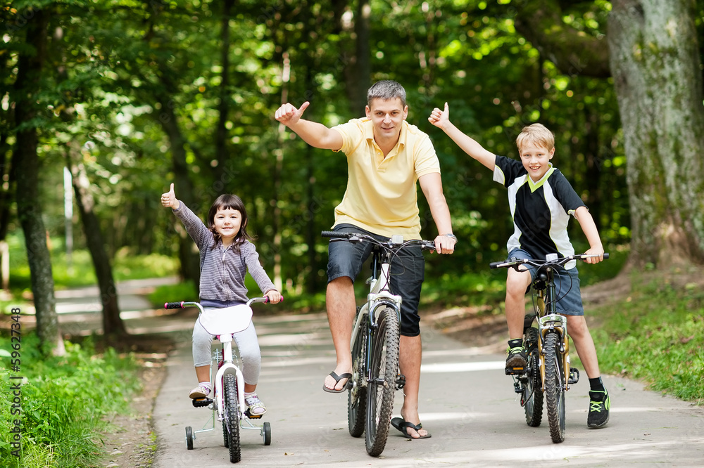 Happy family in the park on bicycles