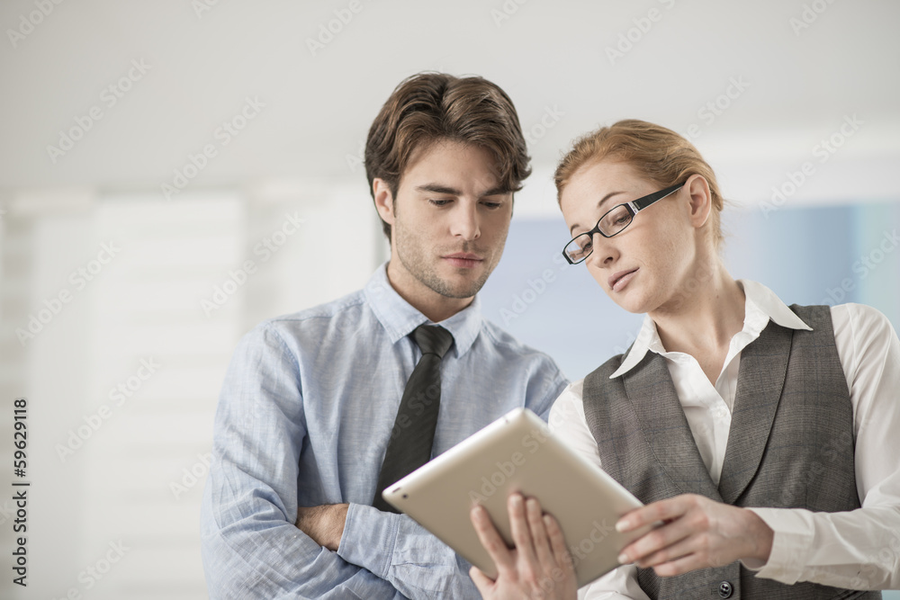two colleagues discuss around a digital tablet two colleagues discuss around a digital tablet