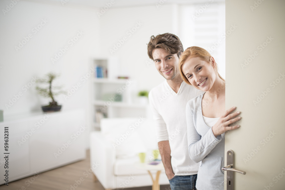 Cheerful couple inviting people to enter in home Cheerful couple inviting people to enter in home