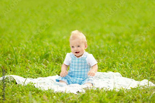 Cute little baby in the park on the grass. Sweet baby outdoors. © Miramiska