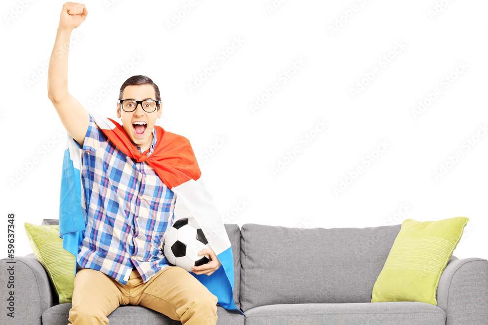 Cheerful male sport fan with soccer ball and flag watching sport Cheerful male sport fan with soccer ball and flag watching sport