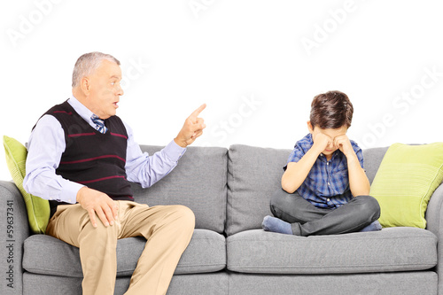 Angry grandad shouting at his nephew, seated on a sofa