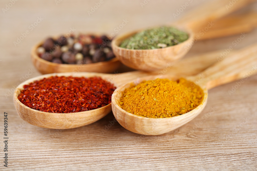 Assortment of spices in wooden spoons on wooden background Assortment of spices in wooden spoons on wooden background