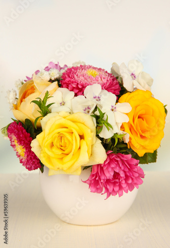 Beautiful bouquet of bright flowers in color vase,