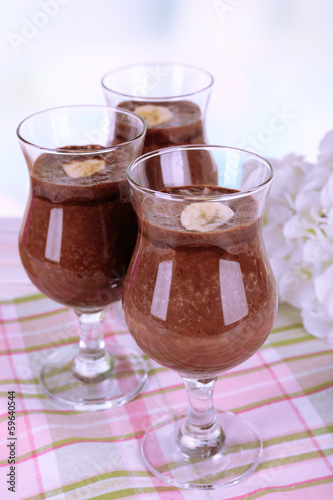 Cocktails with banana and chocolate on table on light