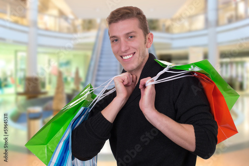 Junger Mann beim Shoppen oder Einkaufen im Geschäft