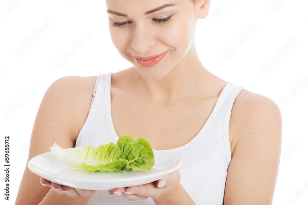 Young slim woman with lettuce on a plate. Young slim woman with lettuce on a plate.