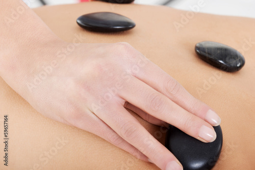 Close up on female's back having stone massage.