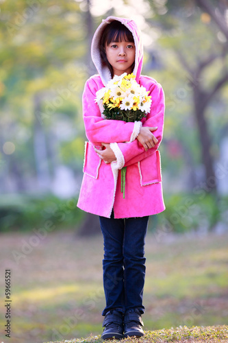 Tableau sur toile Sad little asian girl holding a bunch of flowers