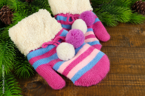 Striped mittens with fir wooden background