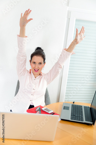 Successful business woman with arms up