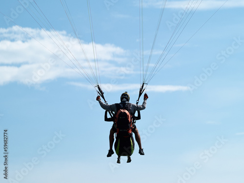 Paragliding against clear blue sky
