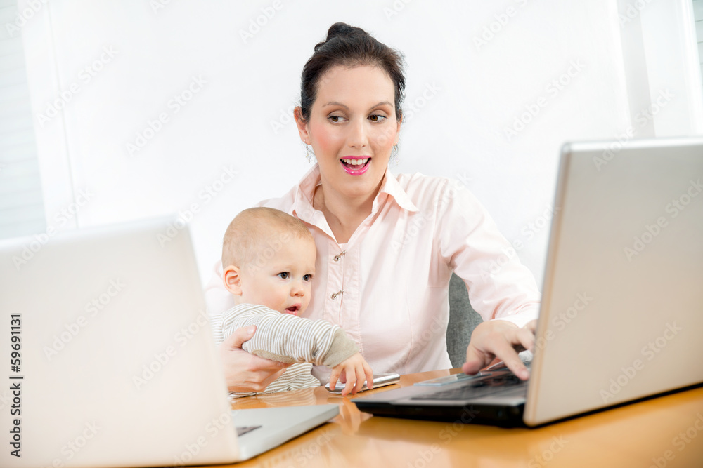 Business woman working in the office with her little baby