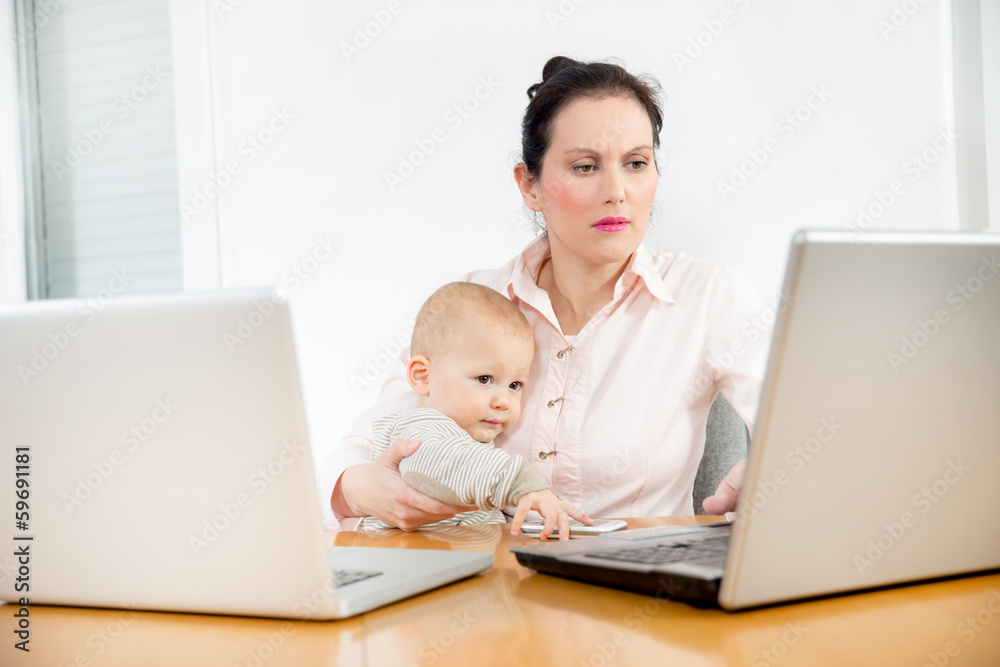 Business woman working in the office with her little baby Business woman working in the office with her little baby