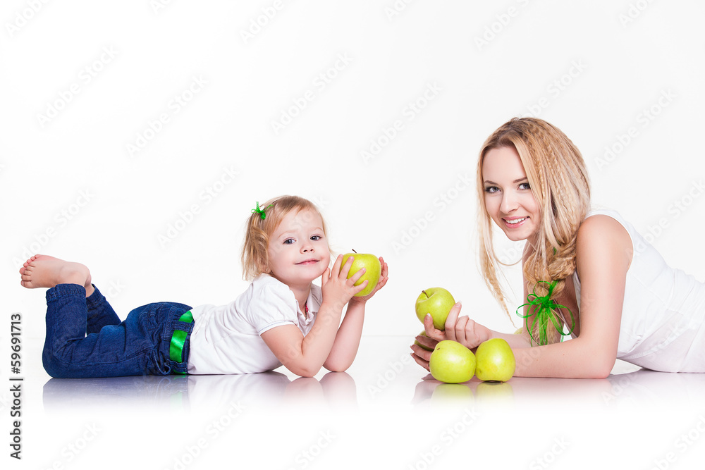 Fototapeta premium portrait of young mother and little daughter with apples