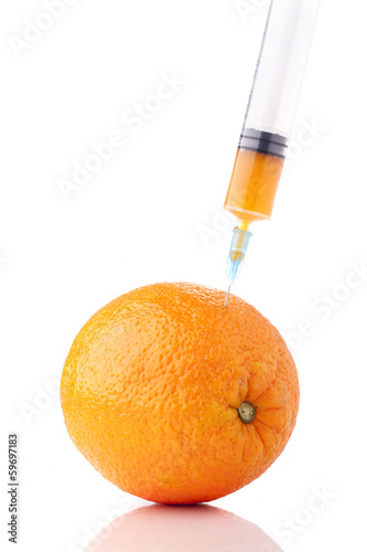 Big orange with a syringe. Concept for GMO.