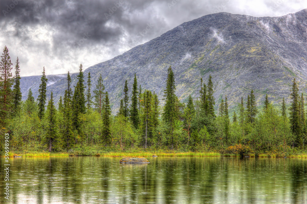 mountain landscape with lake, forest and clouds, rainy, hdr